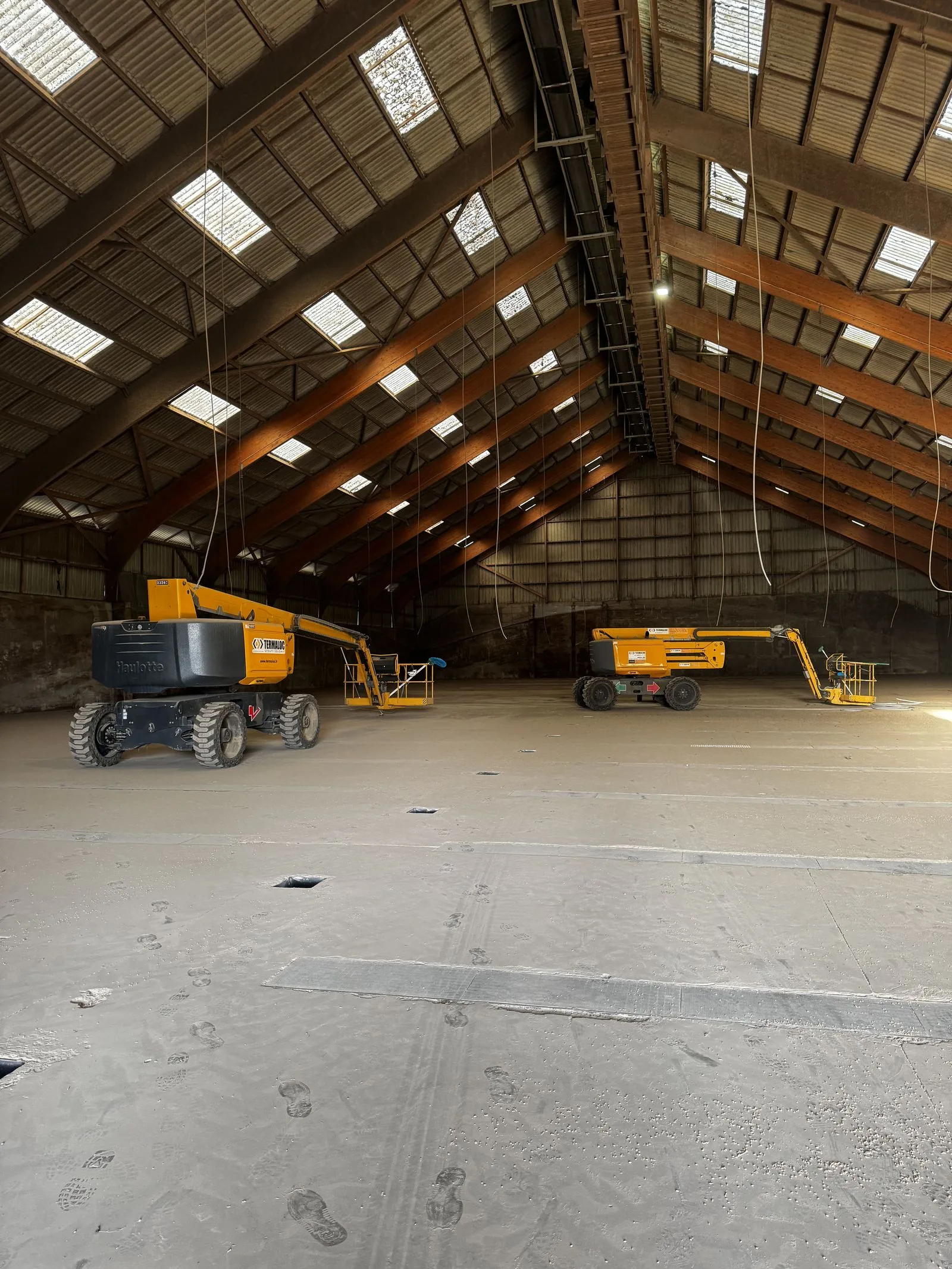 Structure haute d'un hangar agricole vide, charpente et nacelles élévatrices