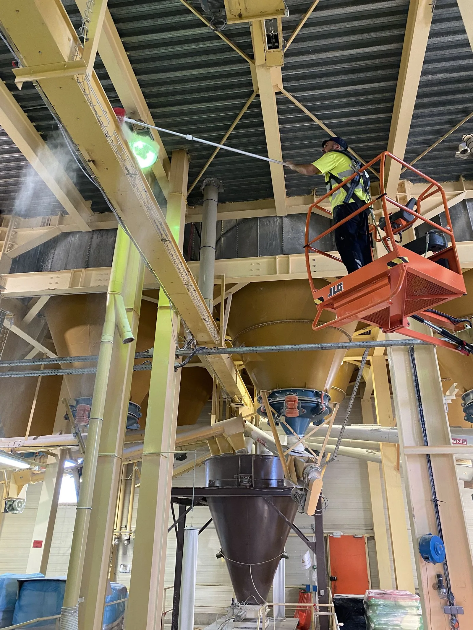 Technicien procédant au nettoyage des structures hautes d'un site industriel
