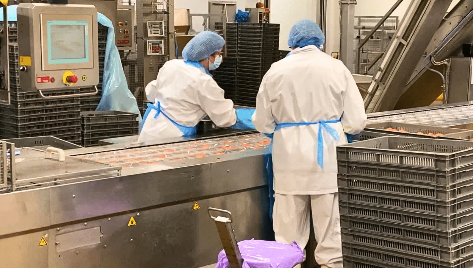 Opérateurs en tenue d'hygiène sur une ligne de conditionnement agroalimentaire