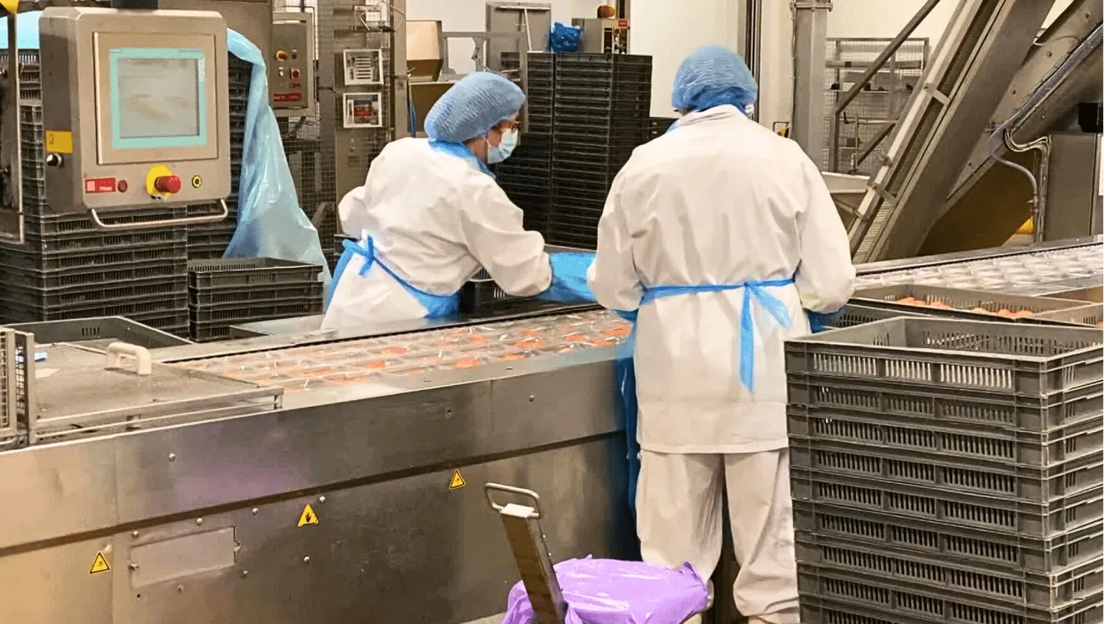 Opérateurs en tenue d'hygiène sur une ligne de conditionnement agroalimentaire